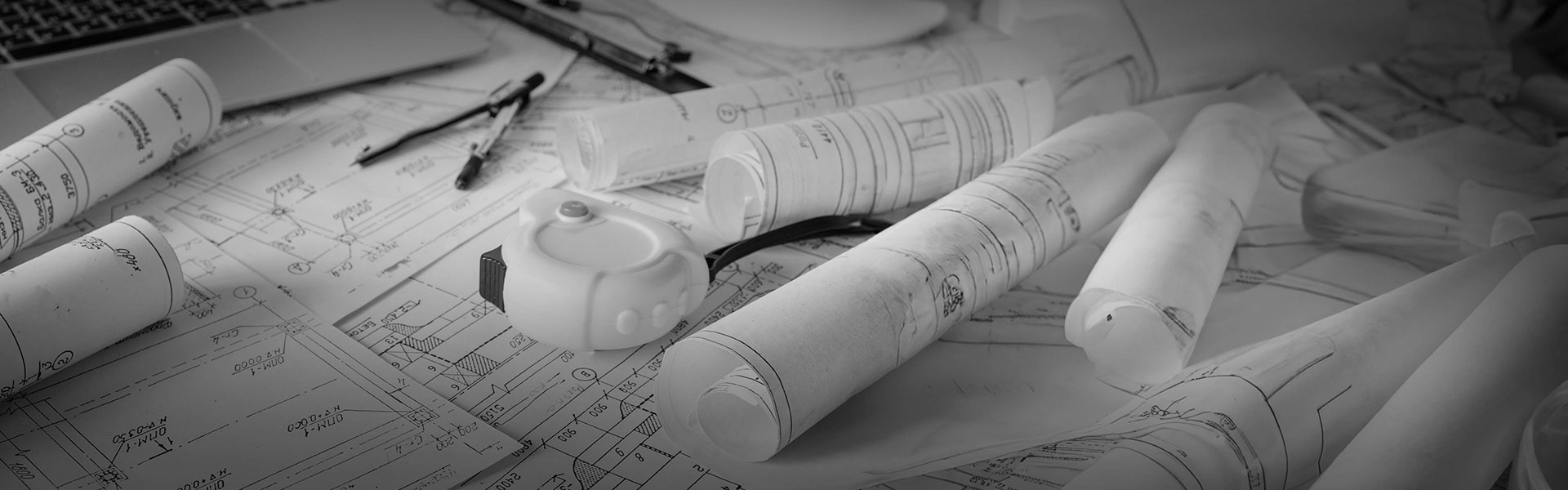 A stack of technical drawings and measuring tools.